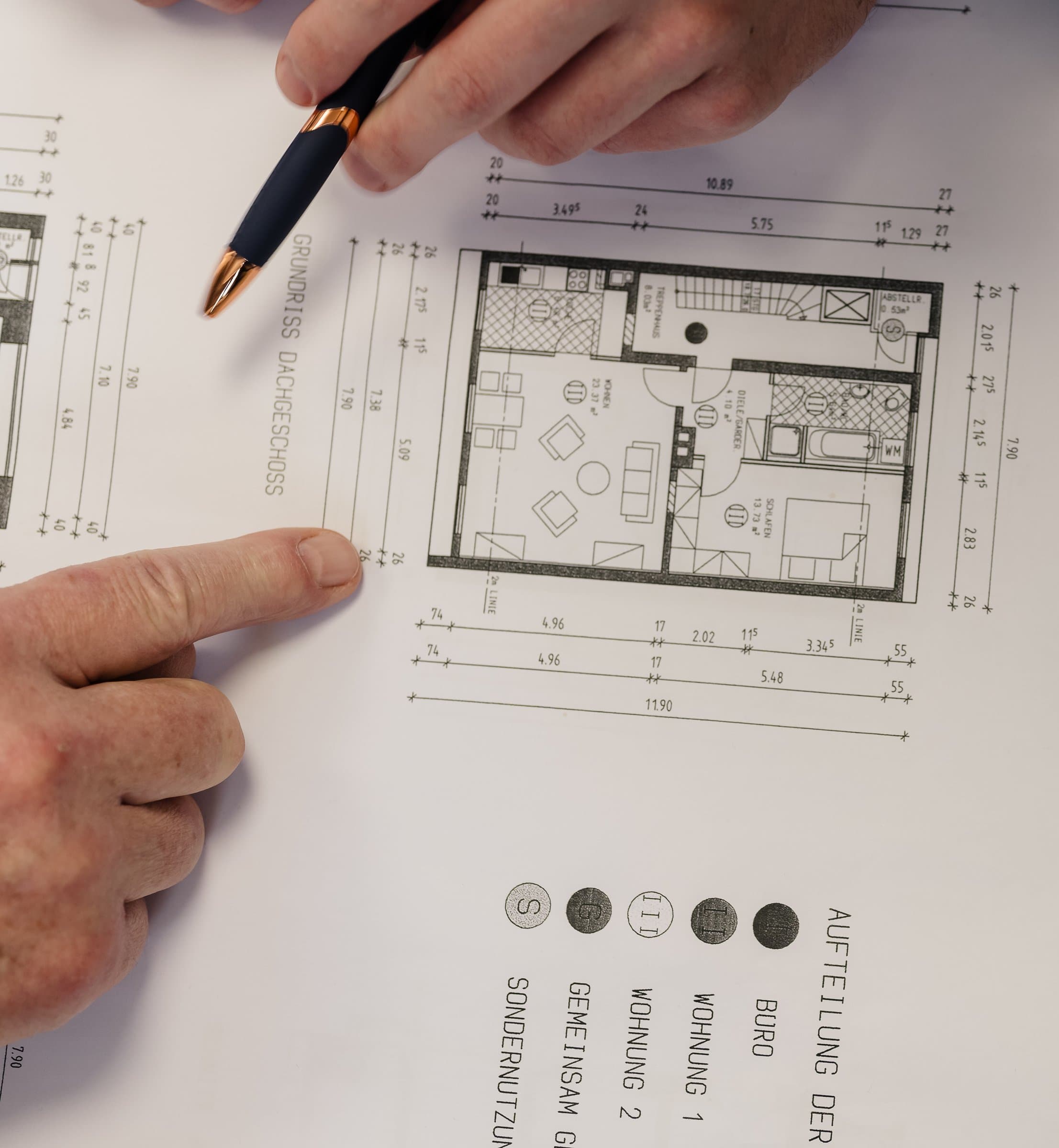 Detail: Hände mit Gutachten, Grundriss und Bodenrichtwertkarte am Besprechungstisch